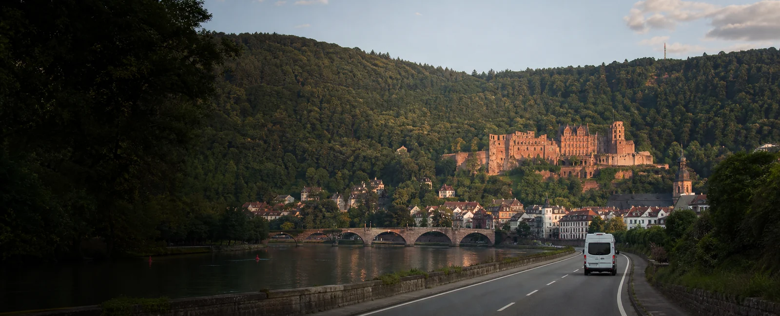 KI-generiertes Routenmotiv: Reisemobil am Neckar vor Heidelberg und der Schlossruine
